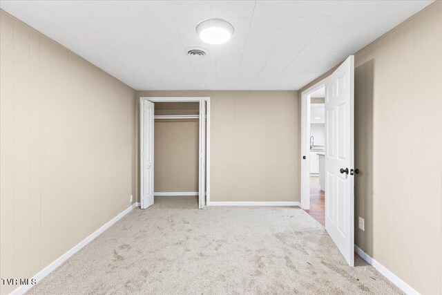 unfurnished bedroom featuring a closet and light carpet