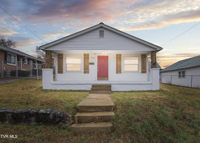 bungalow-style home featuring a lawn and a porch