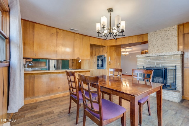 dining room featuring sink, hardwood / wood-style flooring, and a chandelier