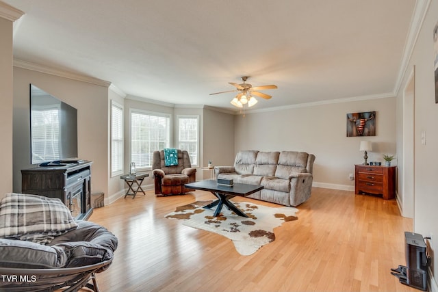 living room featuring ceiling fan, ornamental molding, and light hardwood / wood-style floors