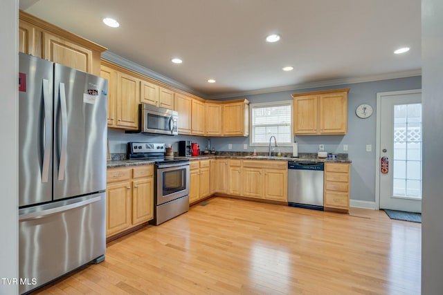 kitchen featuring stainless steel appliances, light hardwood / wood-style flooring, sink, crown molding, and light brown cabinetry