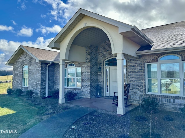 doorway to property featuring a lawn and a patio area