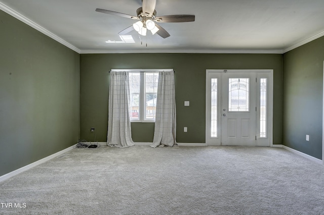 foyer entrance featuring light colored carpet, ornamental molding, and ceiling fan