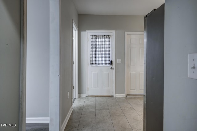 corridor featuring light tile patterned flooring and a barn door