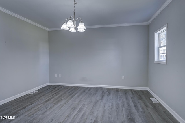 spare room featuring hardwood / wood-style flooring, crown molding, and a notable chandelier