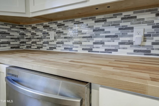 details with tasteful backsplash, white cabinetry, and dishwasher