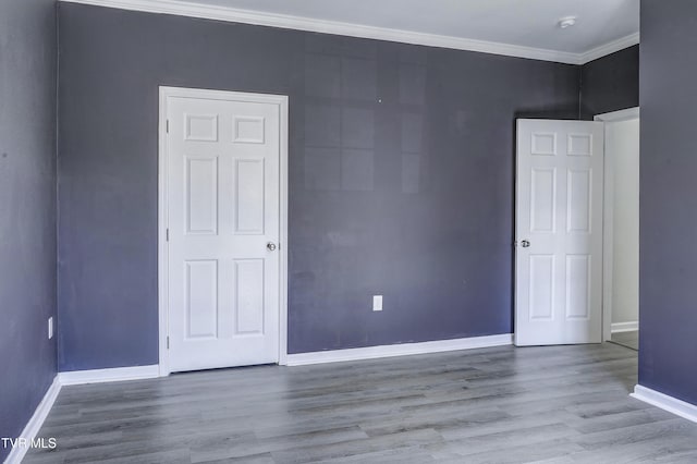 spare room with ornamental molding and light hardwood / wood-style floors