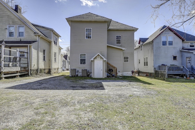 back of property with cooling unit, a yard, and a wooden deck