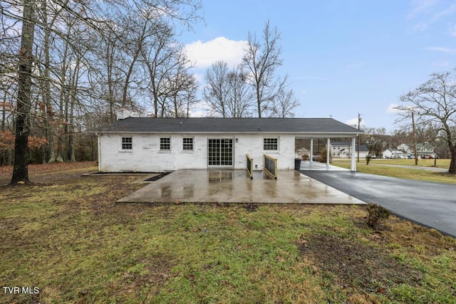 rear view of house featuring a patio area and a lawn