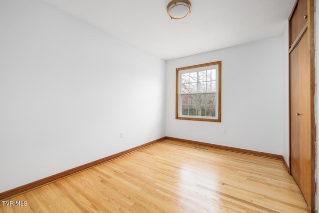 unfurnished bedroom with a closet and light wood-type flooring