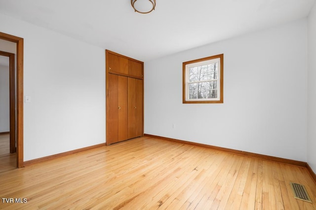 unfurnished bedroom featuring a closet and light wood-type flooring