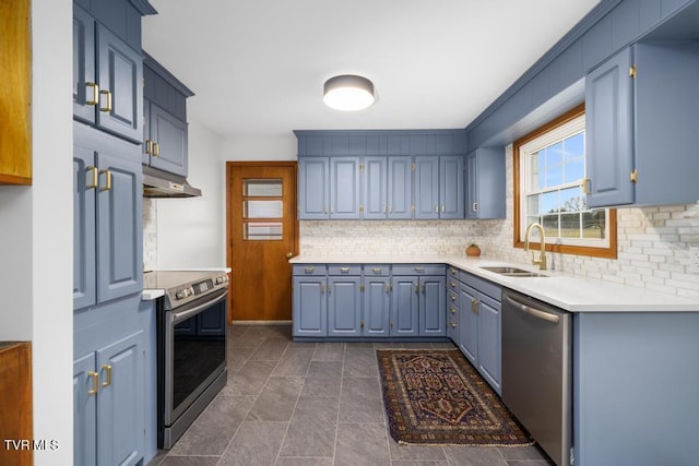 kitchen with appliances with stainless steel finishes, blue cabinets, sink, and decorative backsplash