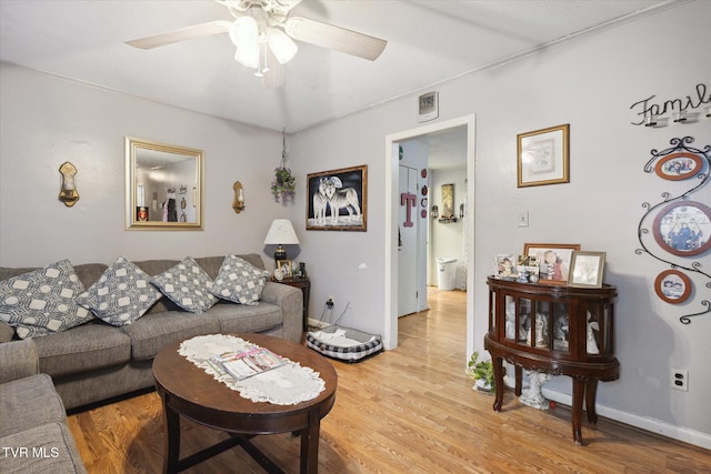 living room featuring light hardwood / wood-style flooring and ceiling fan