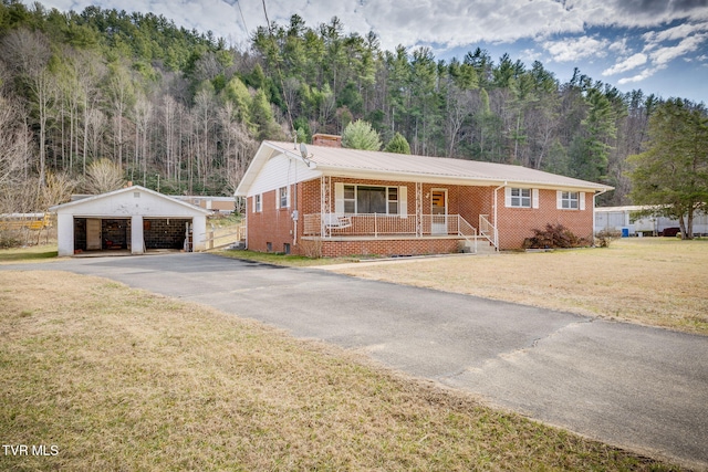 ranch-style house with a garage, a porch, an outbuilding, and a front yard