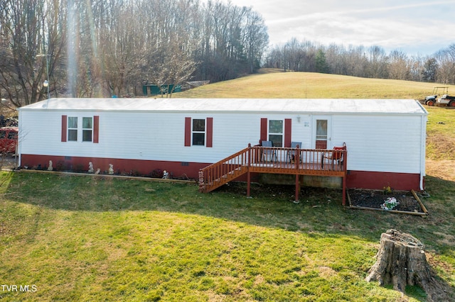 view of front facade with a wooden deck and a front lawn