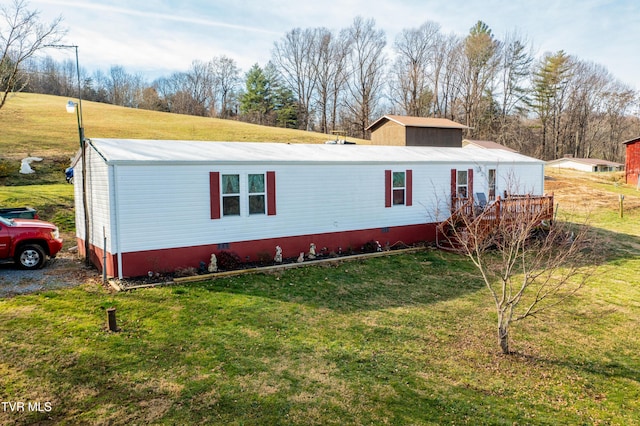 view of front of home with a deck and a front lawn