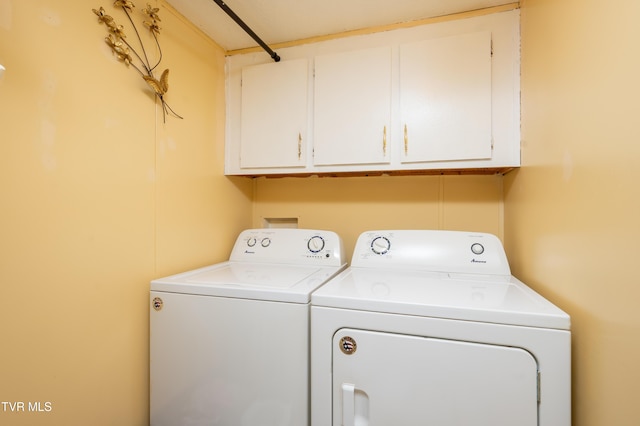 washroom with cabinets and washing machine and clothes dryer