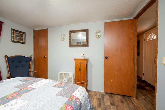 bedroom featuring dark hardwood / wood-style floors and a textured ceiling