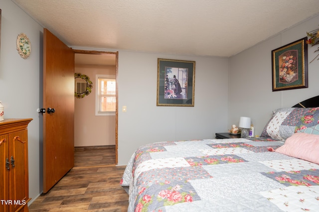 bedroom featuring wood-type flooring and a textured ceiling