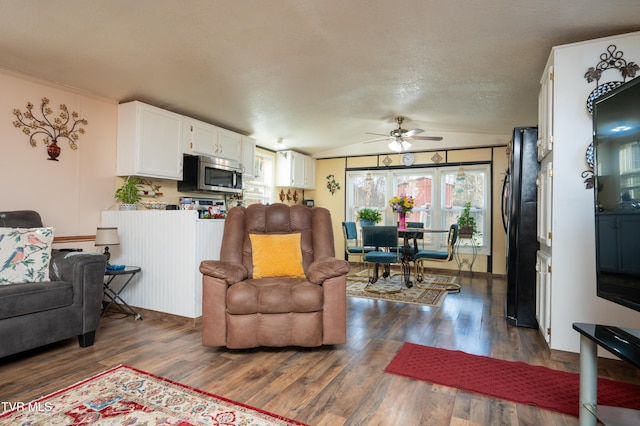 living room featuring vaulted ceiling, dark hardwood / wood-style floors, a textured ceiling, and ceiling fan