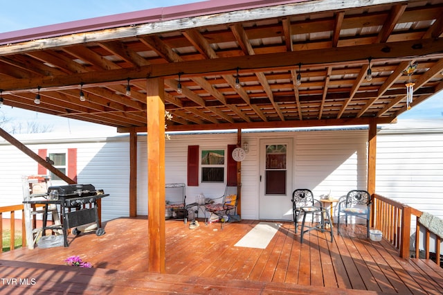 wooden deck featuring a grill