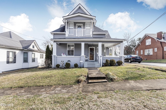 bungalow-style home featuring a porch, a balcony, and a front lawn