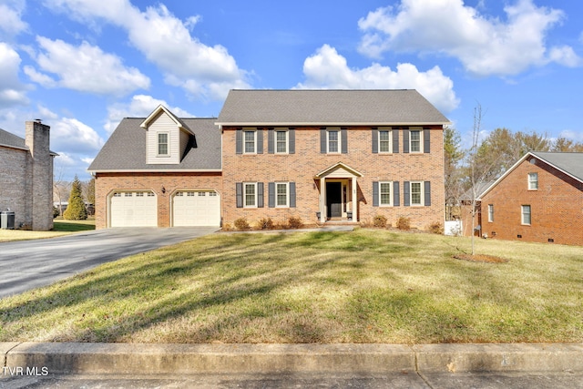 colonial-style house featuring a garage, central air condition unit, and a front lawn