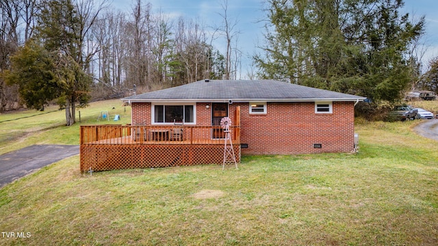 rear view of property with a yard and a deck