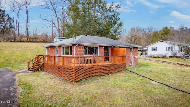 rear view of property featuring a wooden deck and a yard