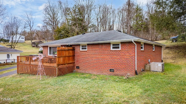 back of house featuring central AC, a deck, and a lawn