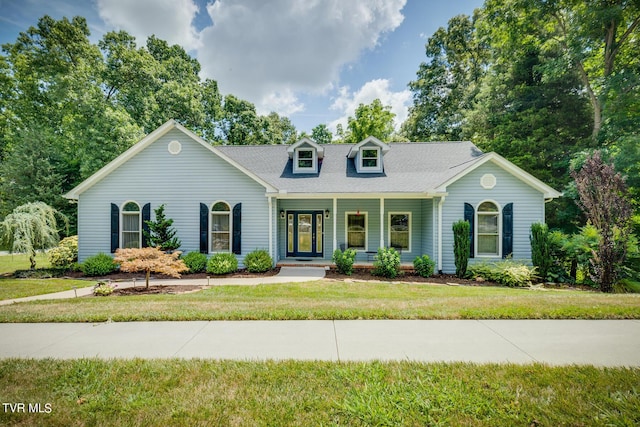 new england style home featuring covered porch and a front yard