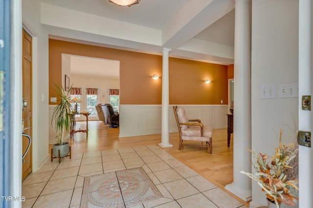 foyer entrance featuring light tile patterned flooring and decorative columns