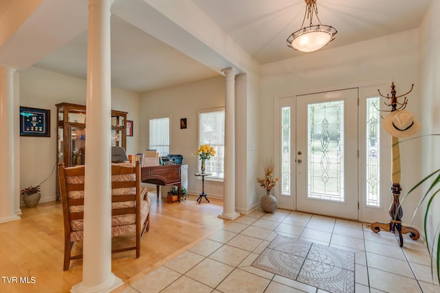 entryway with decorative columns and light tile patterned floors