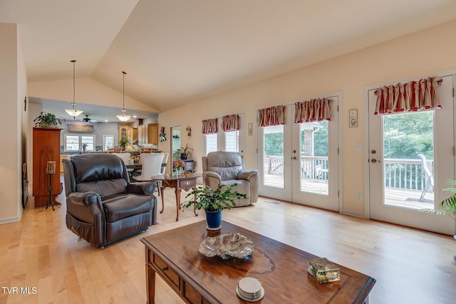 living room with vaulted ceiling, light wood-type flooring, and french doors