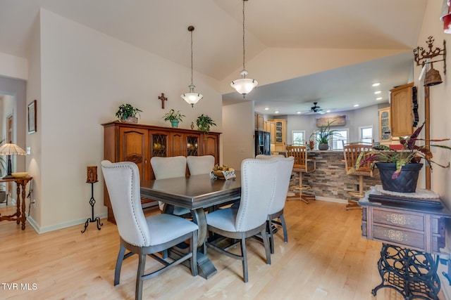 dining space featuring ceiling fan, lofted ceiling, and light hardwood / wood-style flooring