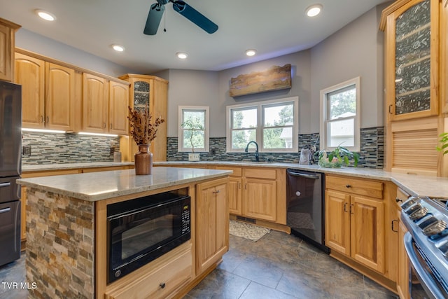 kitchen with tasteful backsplash, a wealth of natural light, black appliances, and a center island