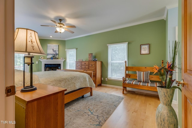 bedroom with ornamental molding, ceiling fan, and light wood-type flooring