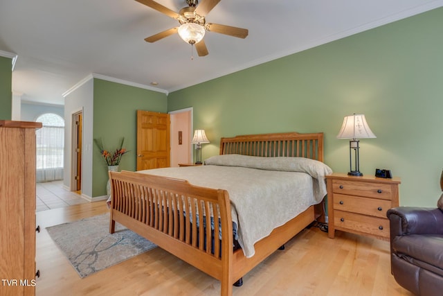 bedroom with ceiling fan, ornamental molding, and light hardwood / wood-style flooring