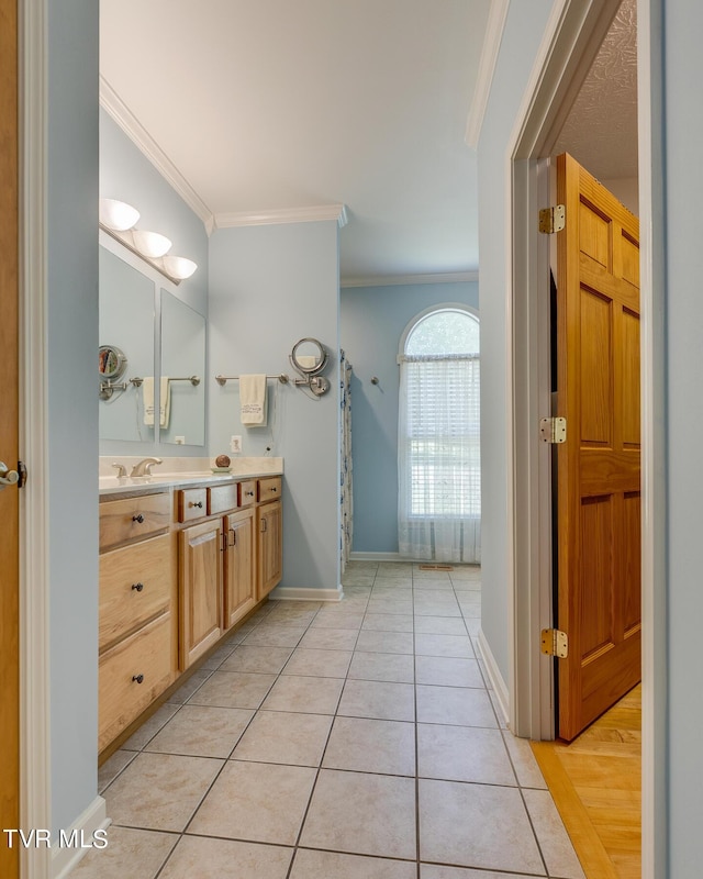 bathroom featuring crown molding, tile patterned floors, and vanity