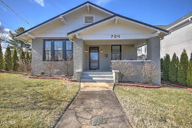 bungalow-style house with a front yard and covered porch