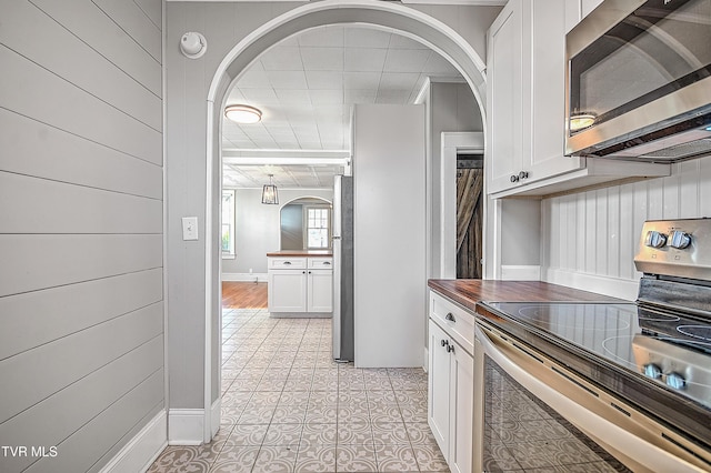 kitchen featuring white cabinetry, light tile patterned floors, and stainless steel appliances