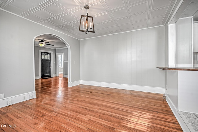 unfurnished dining area with wood-type flooring and ceiling fan with notable chandelier