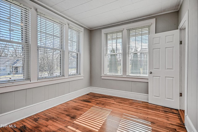 interior space with hardwood / wood-style flooring and ornamental molding