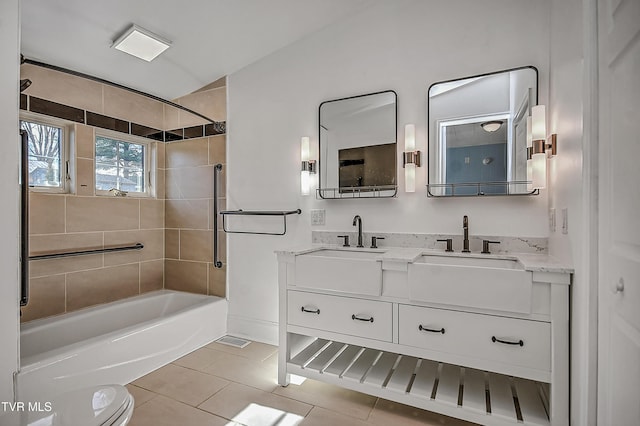 full bathroom featuring tile patterned flooring, vanity, tiled shower / bath combo, and toilet