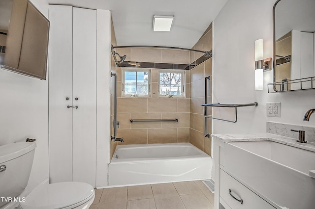 full bathroom with vanity, tiled shower / bath, tile patterned flooring, and toilet