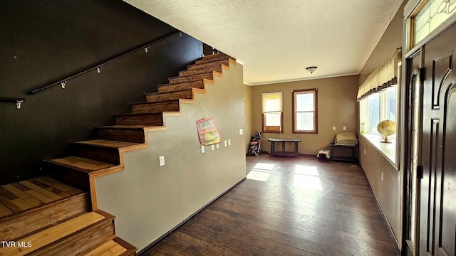 stairs featuring wood-type flooring and a textured ceiling