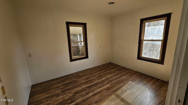 unfurnished room with dark wood-type flooring