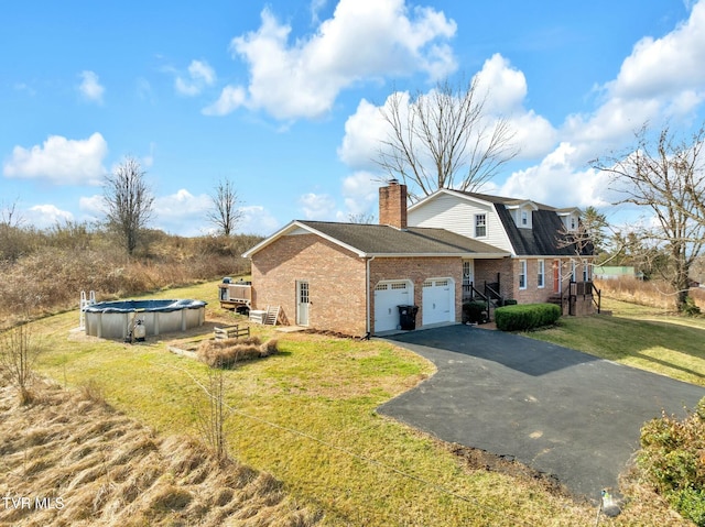 view of side of home featuring a garage, a yard, and a covered pool