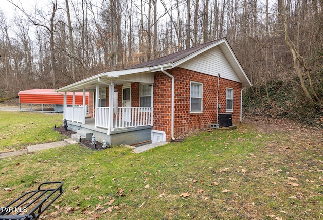 view of front facade with a porch, a front lawn, and a carport