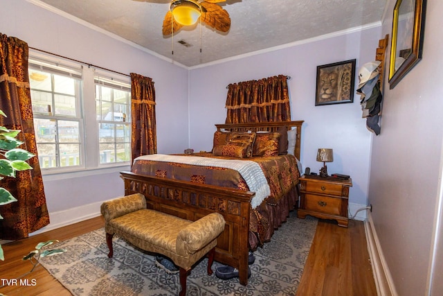 bedroom featuring a textured ceiling, crown molding, ceiling fan, and wood-type flooring